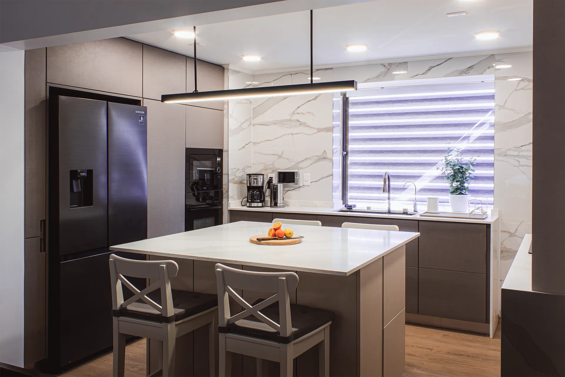 Isla con taburetes y refrigerador negro, Cocina Las Camelias