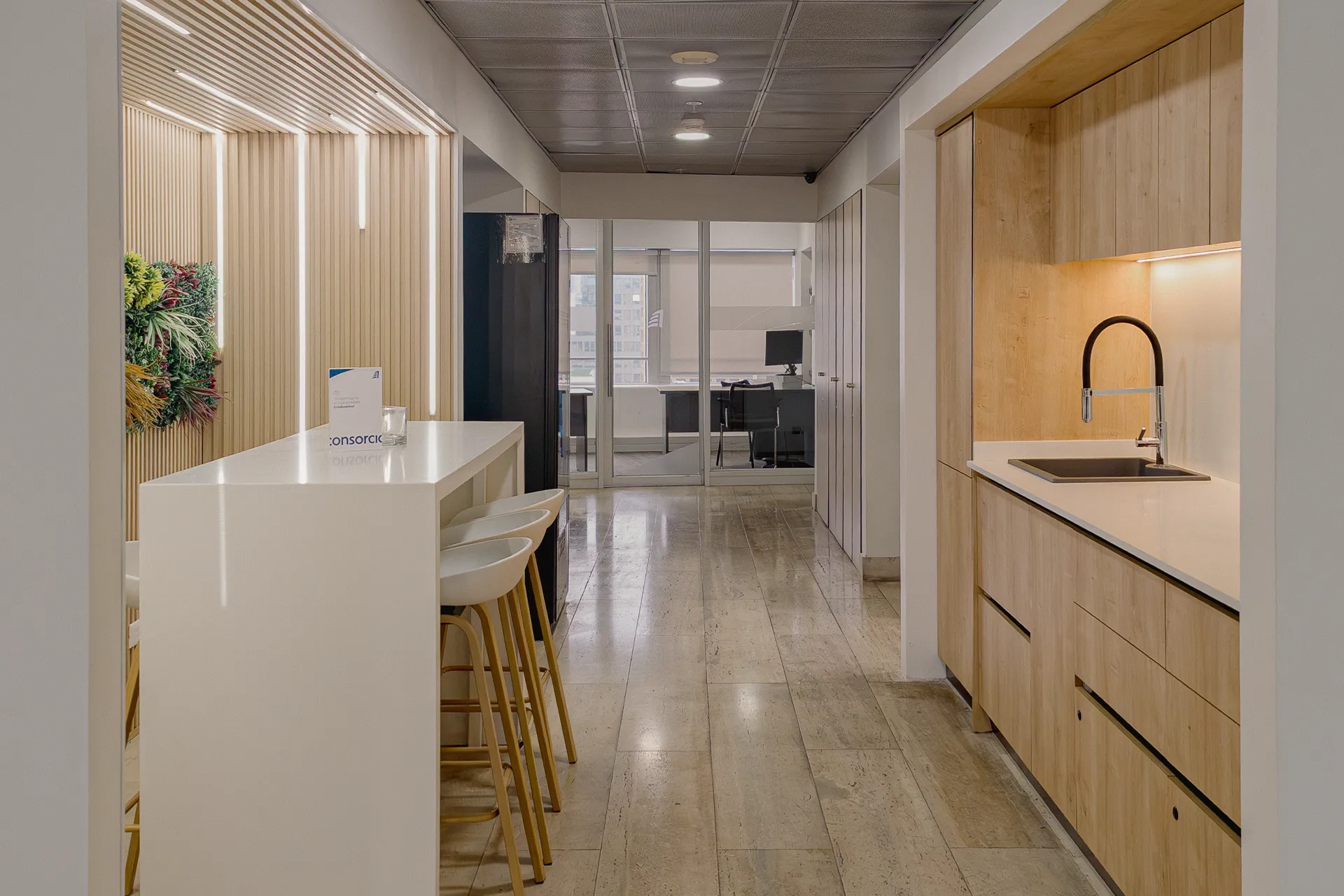 Coffee corner corporativo con barra de café y muebles de madera clara, Coffee Corner Consorcio